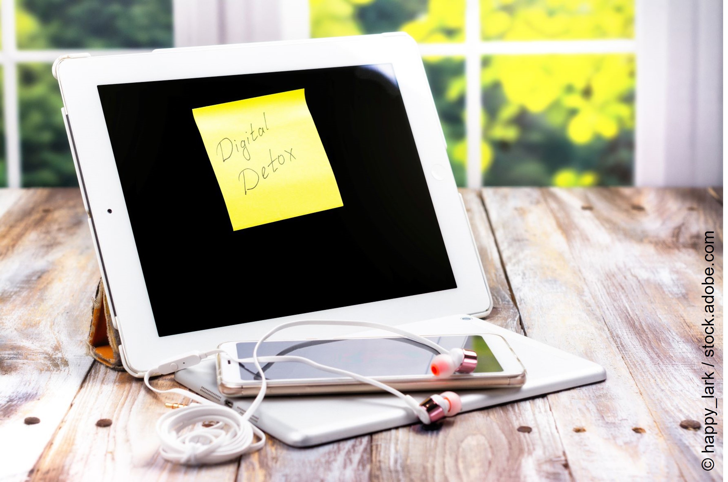 Ein ausgeschaltetes Tablet und ein Handy liegen auf dem Tisch. Auf dem Tablet ist ein Post-It auf dem steht: Digital Detox. 